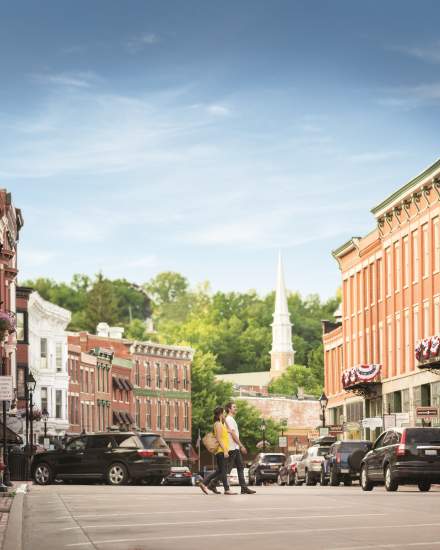 A couple walking across the main street in Galena with buildings either side