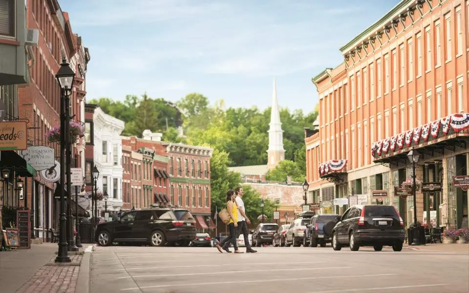 A couple walking across the main street in Galena with buildings either side