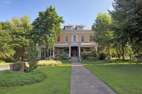 A mansion with a walkway and trees