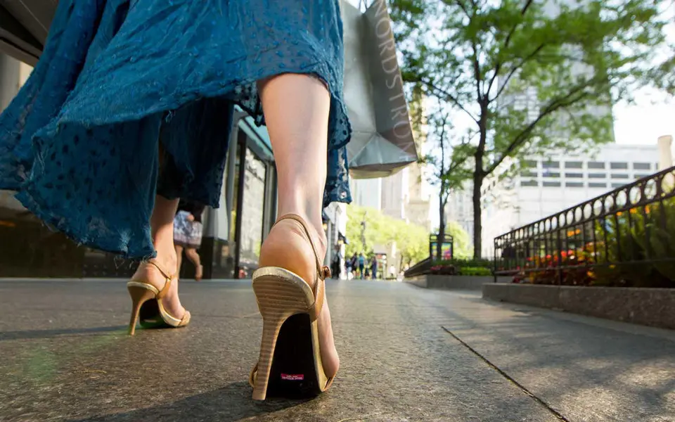 A woman in high heels walks past the shops on Chicago’s Magnificent Mile.