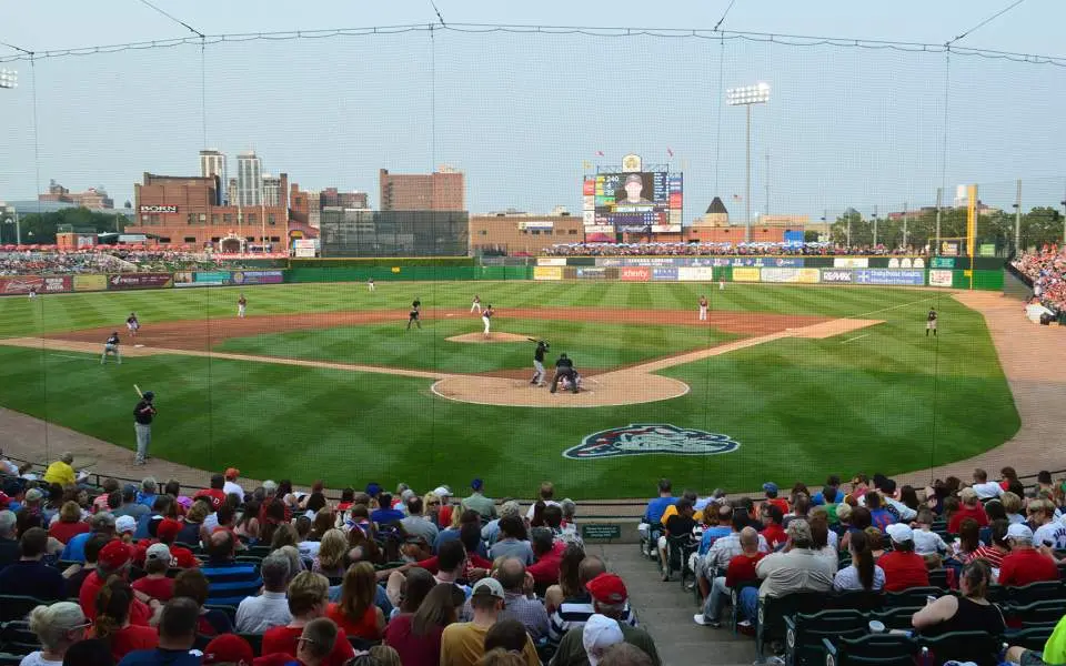 Full stands of spectators watch a baseball game being played