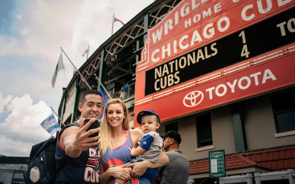 A family taking a photo in front of the Wrigley Field Stadium