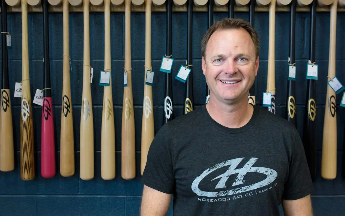 Man standing in front of wooden bats