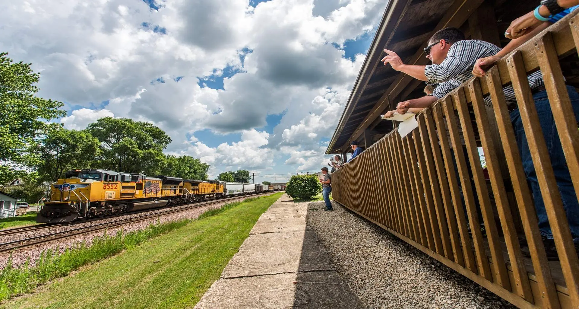 People watching a train pass by at a railroad park